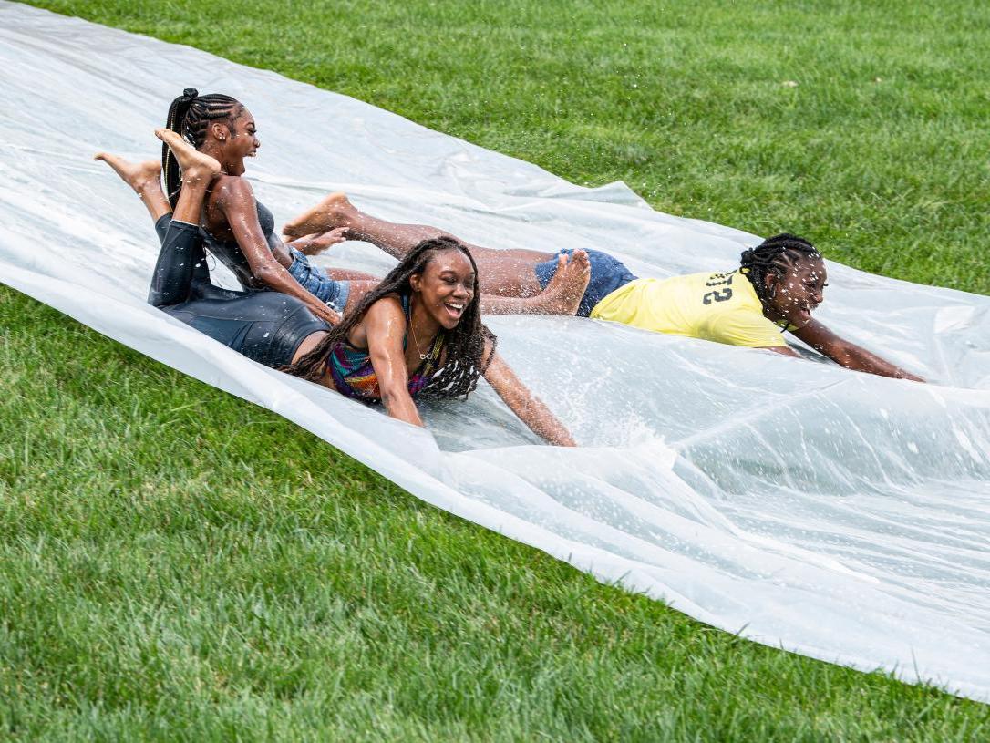 Students on a water slide on campus.